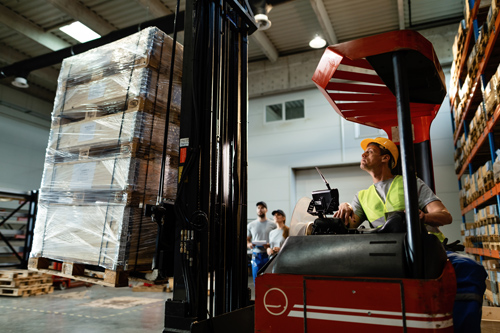 trabajador en almacen cargando cajas.